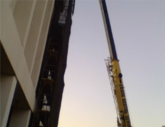 Crane setting wall cages at the exterior
