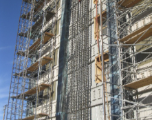 Wall cages rising beside FRP-wrapped columns